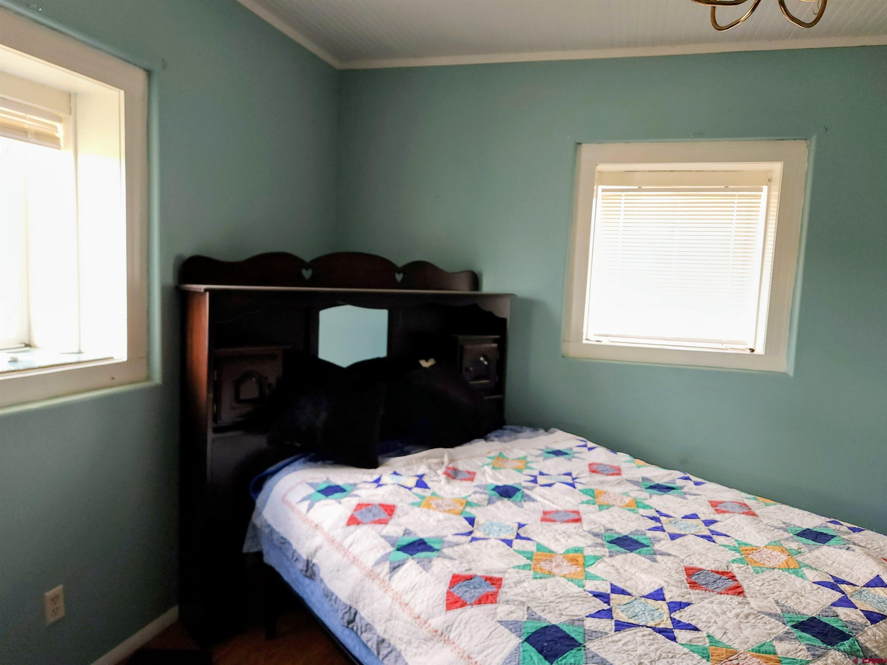 12753 13.5 Road Antonito, CO 81120 - Photo 18 of 39 a bedroom with a bed and window
