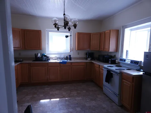 a kitchen with kitchen island granite countertop a sink window and stainless steel appliances