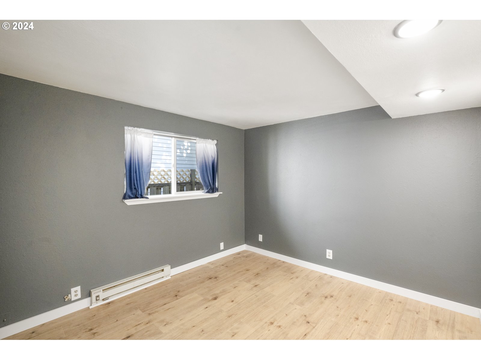 604 Northeast 93rd Avenue Portland, OR 97220 - Photo 12 of 34 an empty room with wooden floor and windows