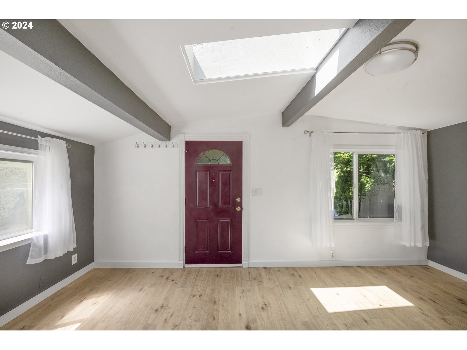 604 Northeast 93rd Avenue Portland, OR 97220 - Photo 4 of 34 a view of an empty room with wooden floor and a window