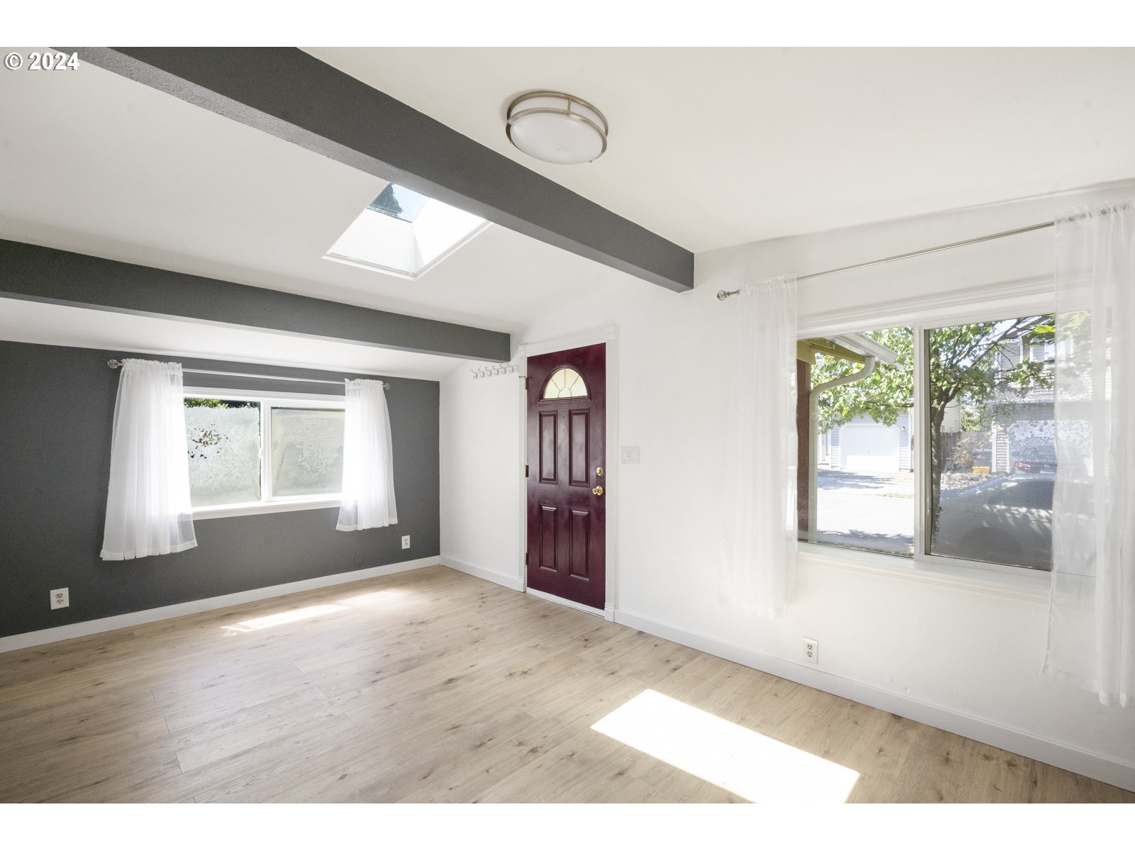 604 Northeast 93rd Avenue Portland, OR 97220 - Photo 5 of 34 a view of an empty room with wooden floor and a window