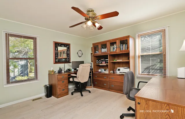 a workspace with furniture window and a ceiling fan
