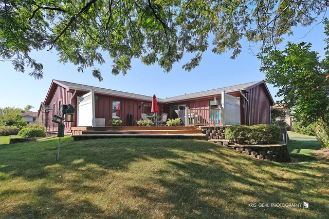 a front view of house with yard and trees in the background
