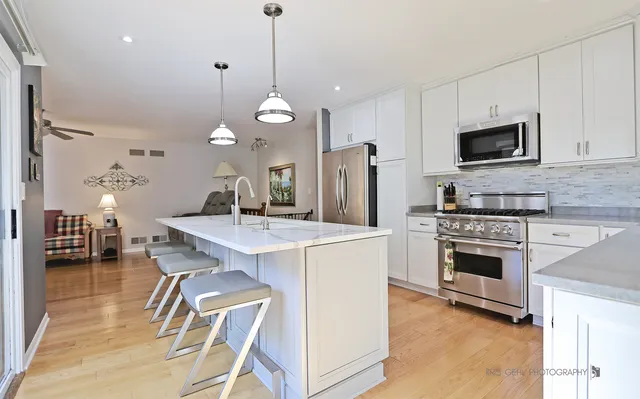 a kitchen with kitchen island a stove and a microwave