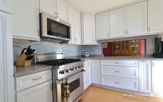 a kitchen with stainless steel appliances granite countertop a stove a microwave and cabinets