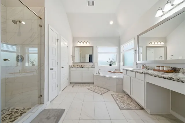a large bathroom with a double vanity sink a mirror and a shower