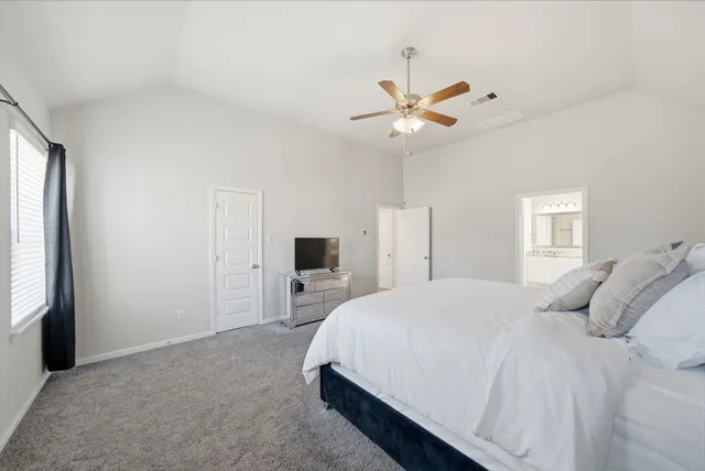 a bedroom with a large bed and a chandelier