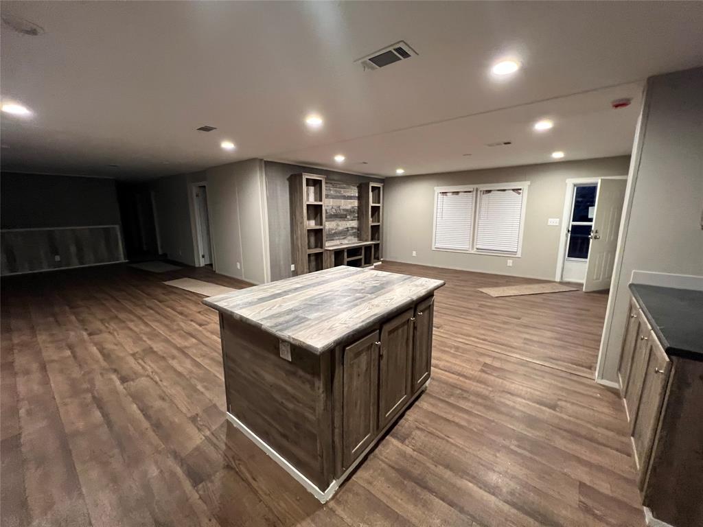 197 Sweden Street Walnut Springs, TX 76690 - Photo 8 of 27 an open kitchen with kitchen island a sink appliances and a counter top space