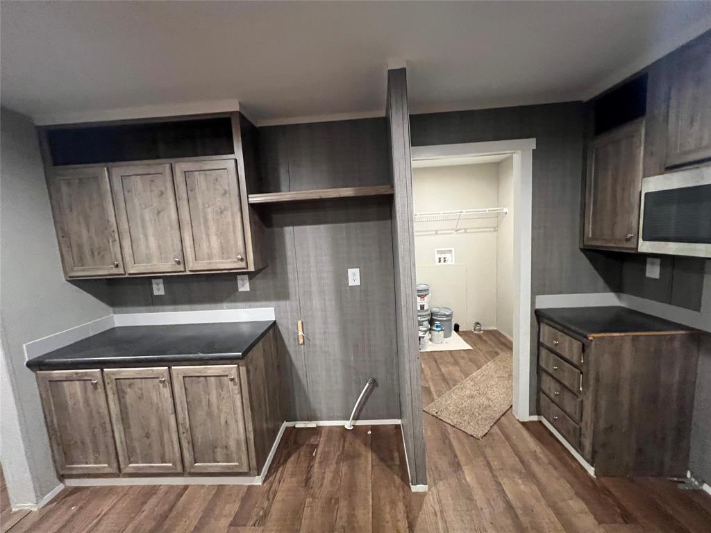 197 Sweden Street Walnut Springs, TX 76690 - Photo 9 of 27 a kitchen with a sink a refrigerator and wooden cabinets