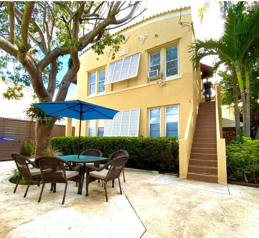 a view of house with backyard and furniture