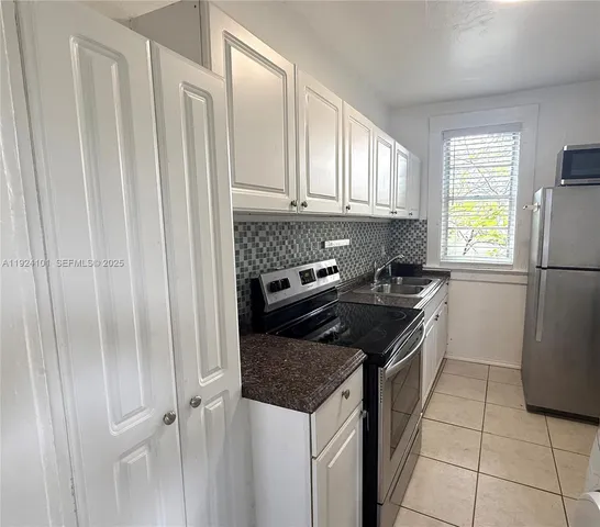 a kitchen with a stove a refrigerator and a stove top oven
