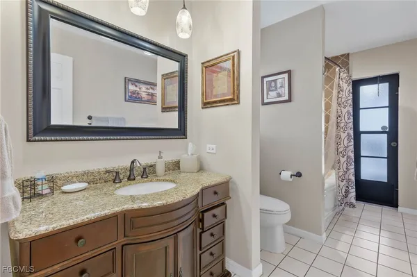 a bathroom with a granite countertop sink a toilet and a mirror