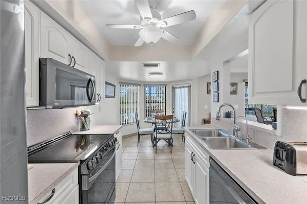 a large kitchen with stainless steel appliances granite countertop a sink stove and refrigerator
