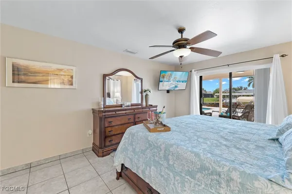 a bedroom with a bed dresser and a large window