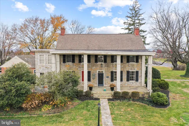 a front view of a house with yard and trees