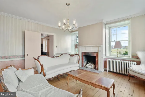 an empty room with wooden floor a fireplace and window