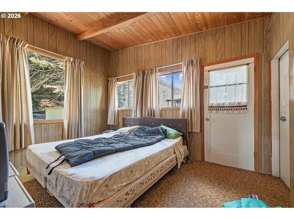 a bedroom with a bed and large window