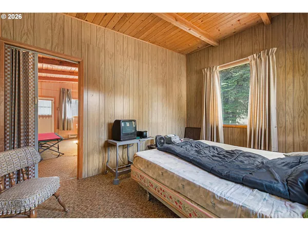 a bedroom with a bed dresser and a window