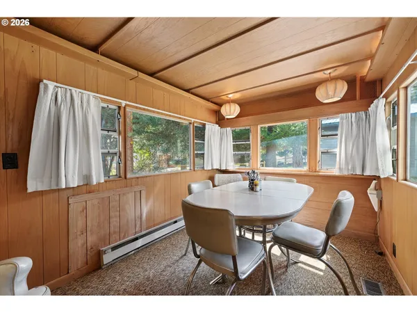 a dining room with furniture large windows and a chandelier
