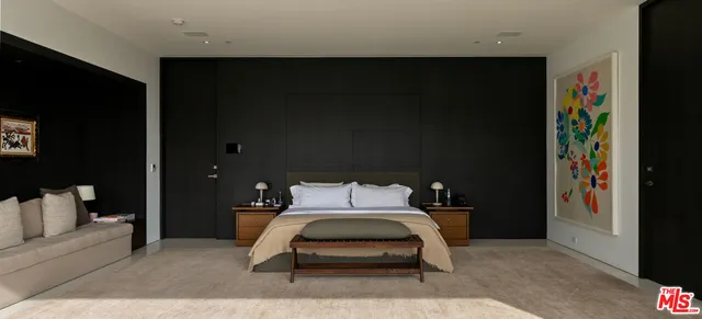 a bedroom with a bed and a tv on the dresser