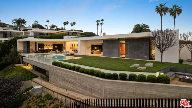 a front view of a house with a garden and a table and chairs