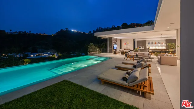 a view of a patio with table and chairs with plants and wooden fence