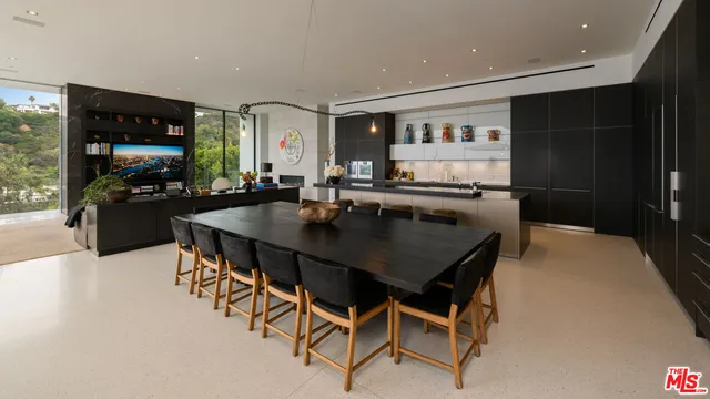 a kitchen with a table chairs and flat screen tv