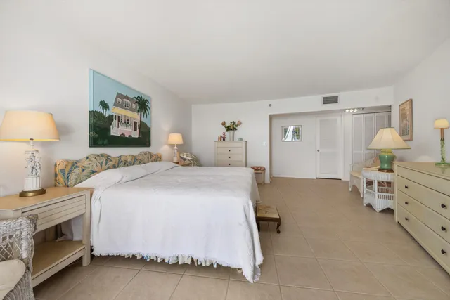 a spacious bedroom with a bed and a lamp