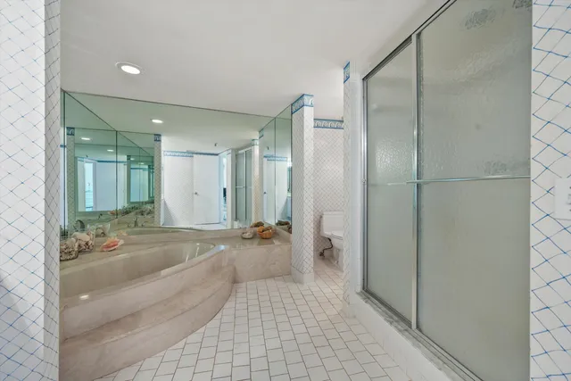 a bathroom with a tub shower and mirror