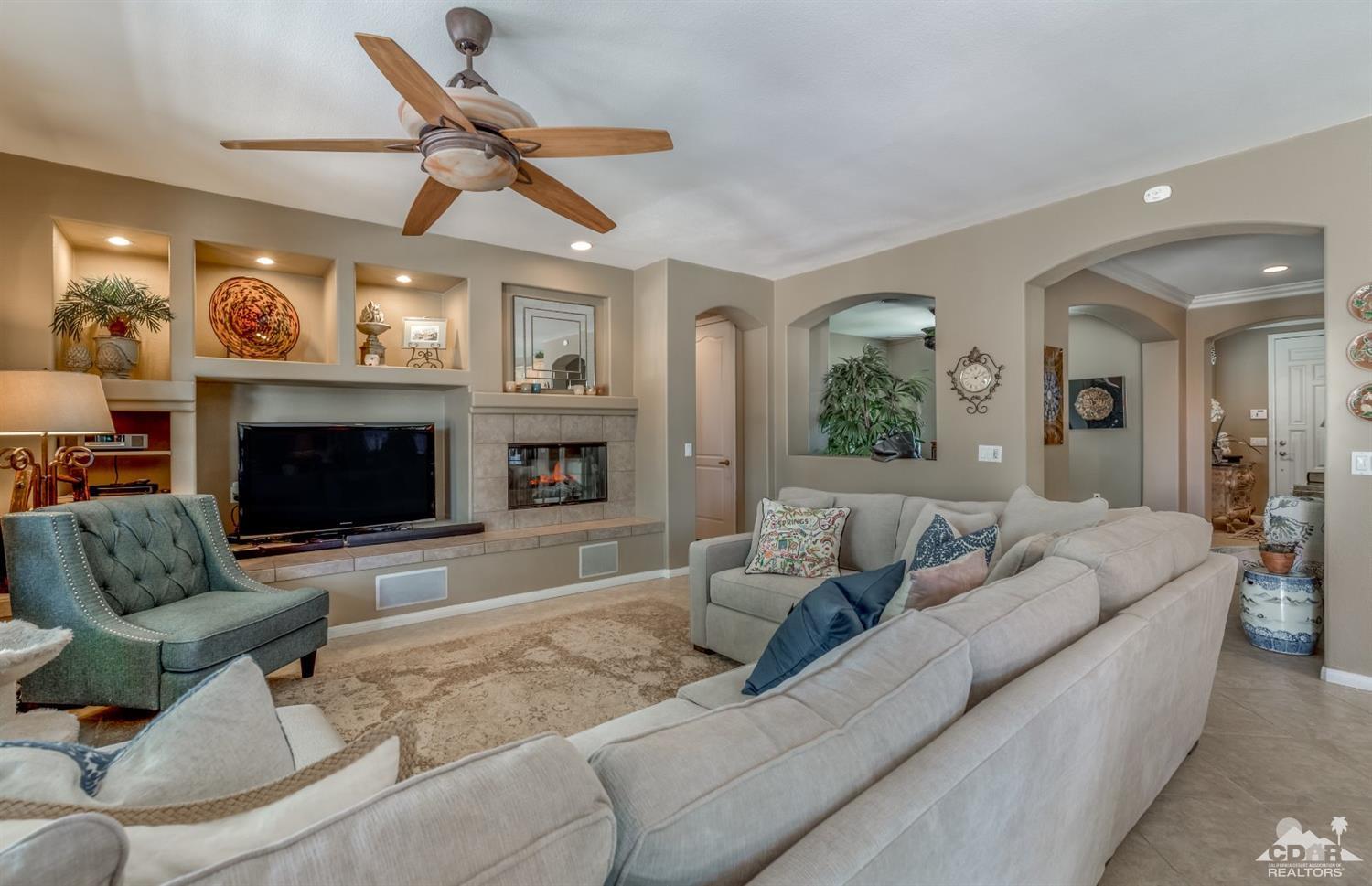 145 Via Solaro Rancho Mirage, CA 92270 - Photo 2 of 40 a living room with furniture ceiling fan and a fireplace