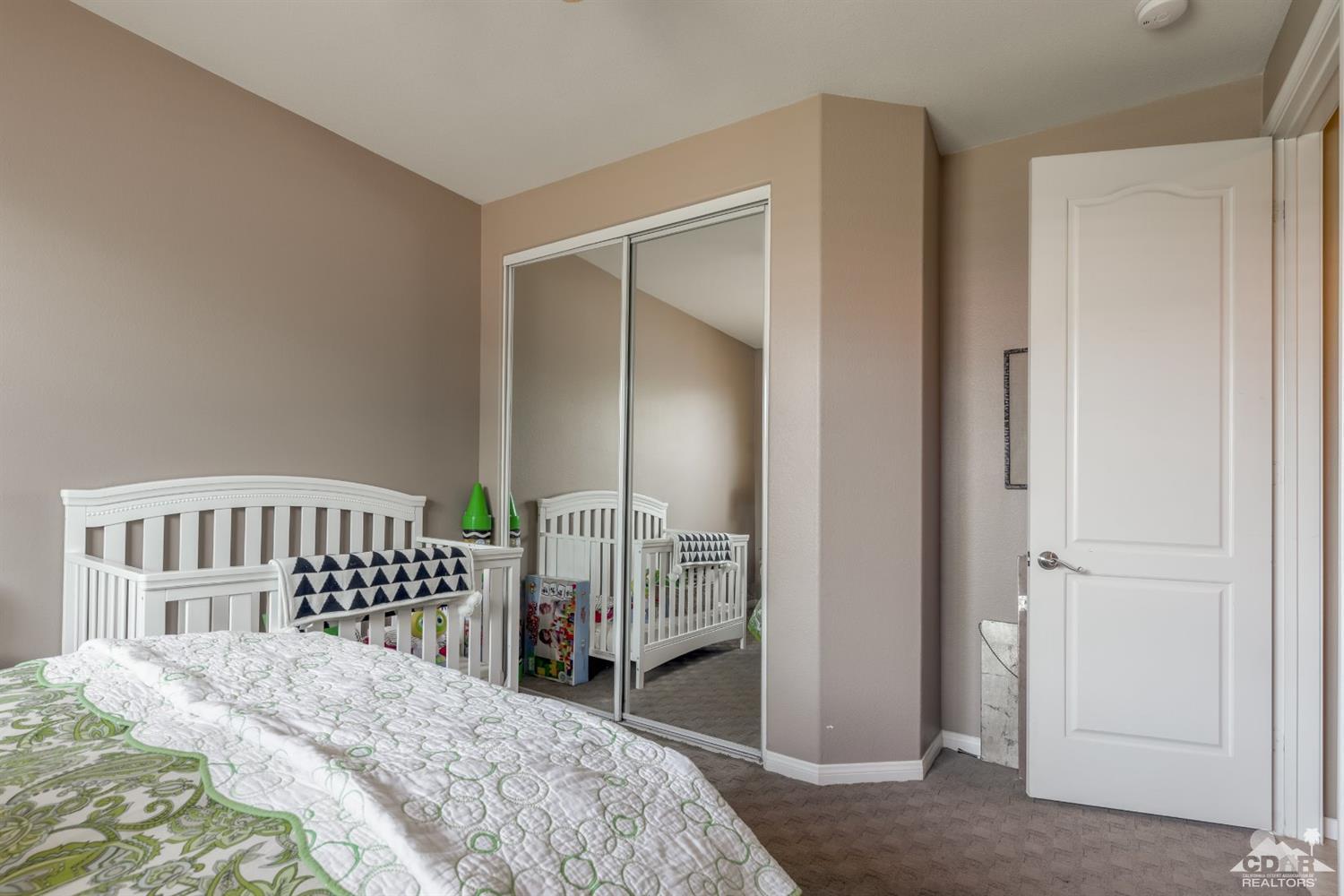 145 Via Solaro Rancho Mirage, CA 92270 - Photo 11 of 40 a bedroom with a bed and wooden floor