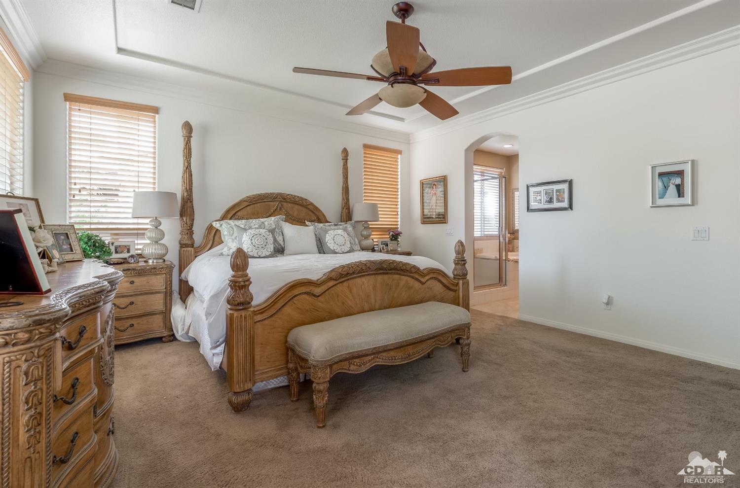 145 Via Solaro Rancho Mirage, CA 92270 - Photo 15 of 40 a bedroom with a bed and a chandelier