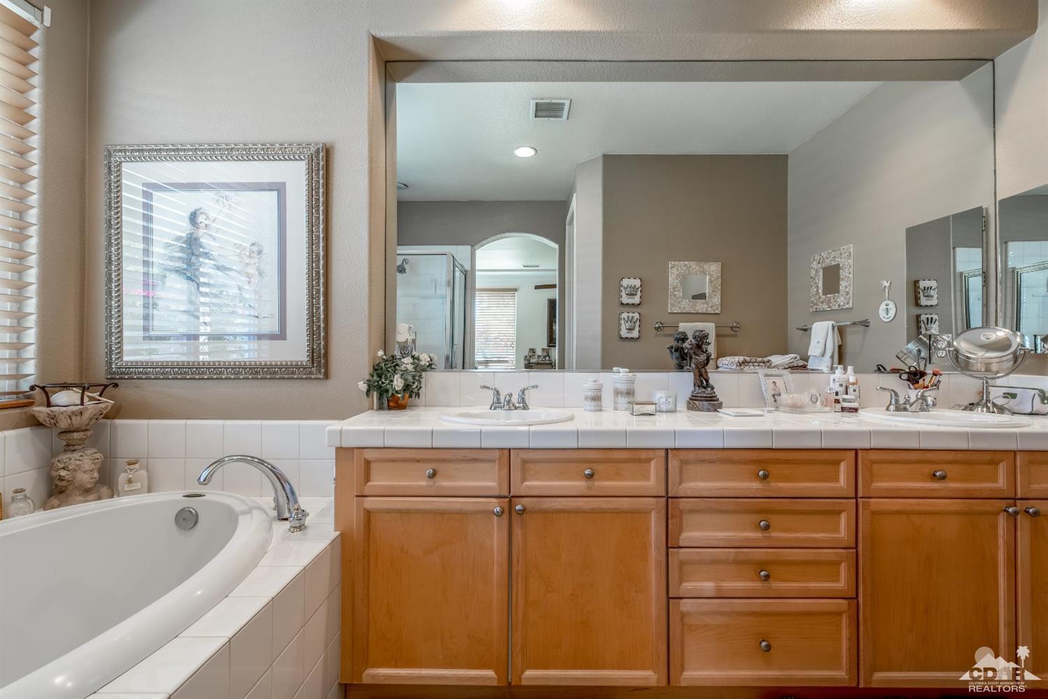 145 Via Solaro Rancho Mirage, CA 92270 - Photo 22 of 40 a bathroom with a granite countertop sink mirror and bathtub