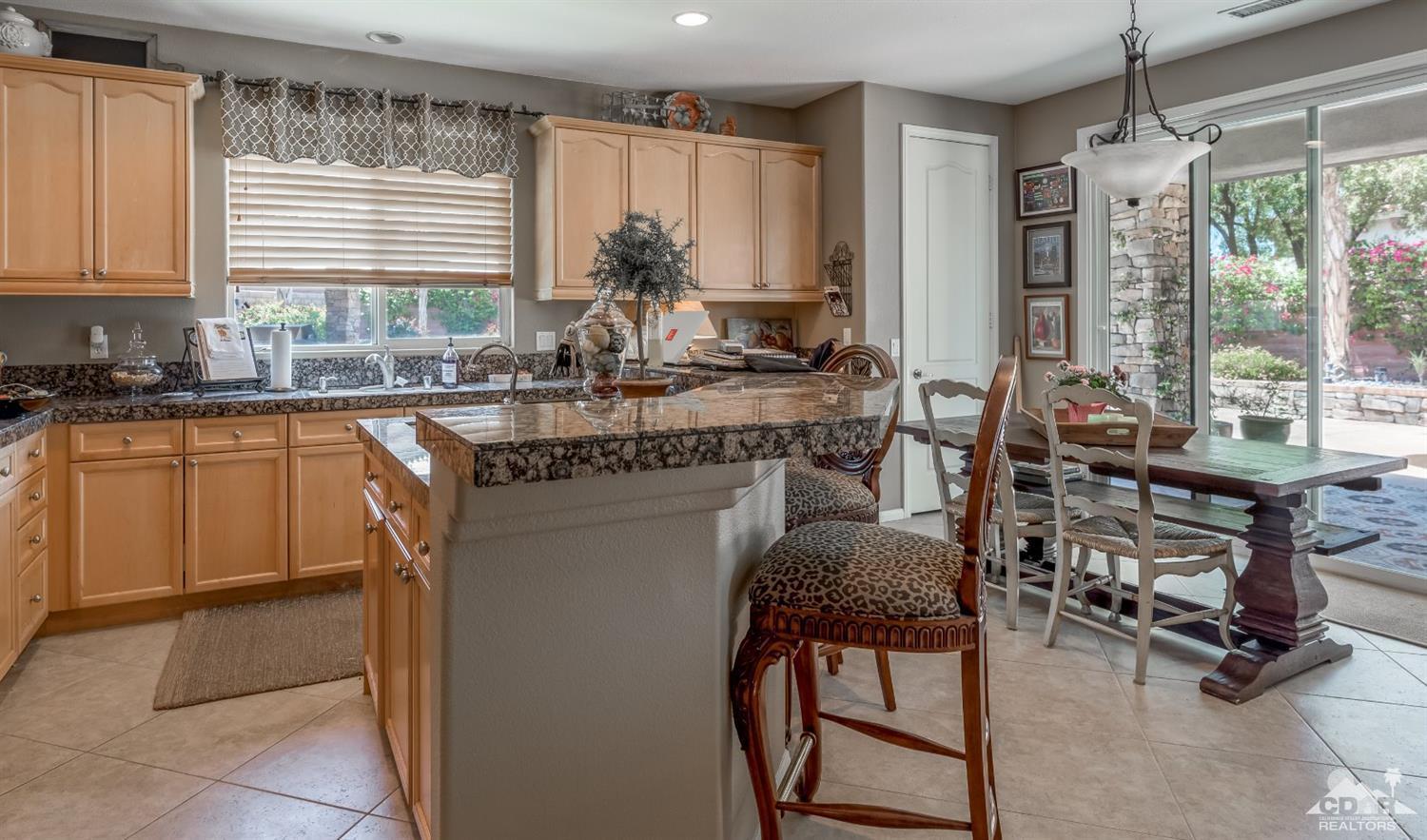 145 Via Solaro Rancho Mirage, CA 92270 - Photo 4 of 40 a kitchen with kitchen island a large window in it and dining table