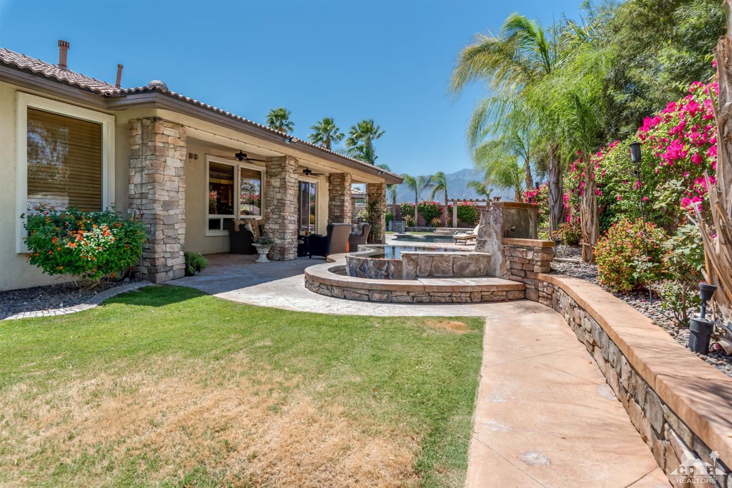 145 Via Solaro Rancho Mirage, CA 92270 - Photo 31 of 40 a front view of a house with fountain and potted plants
