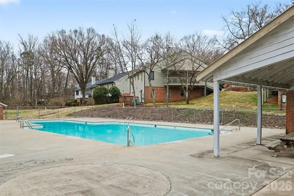 a view of backyard with swimming pool and seating space