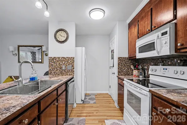 a kitchen with stainless steel appliances granite countertop a sink stove oven and cabinets