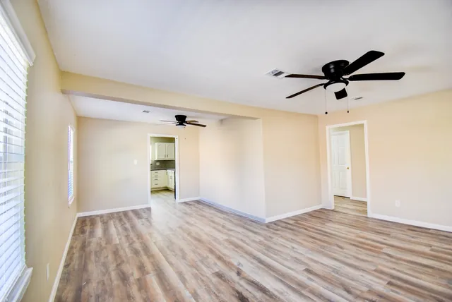 a view of room with wooden floor and ceiling fan