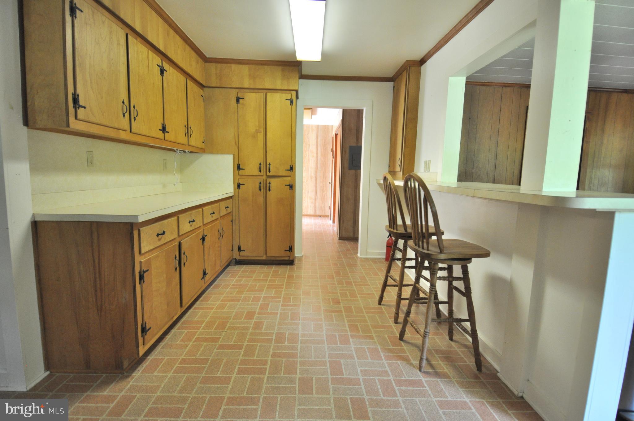 635 Cedar Hall Road Pocomoke City, MD 21851 - Photo 15 of 48 a kitchen with a sink a refrigerator and chairs