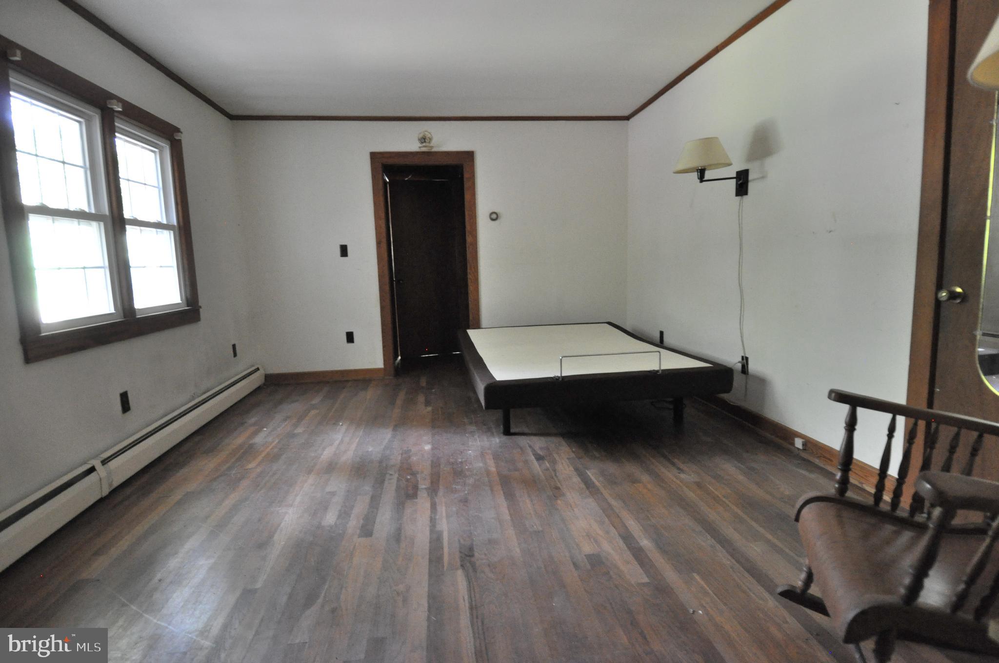 635 Cedar Hall Road Pocomoke City, MD 21851 - Photo 35 of 48 a living room with a bed furniture and a wooden floor