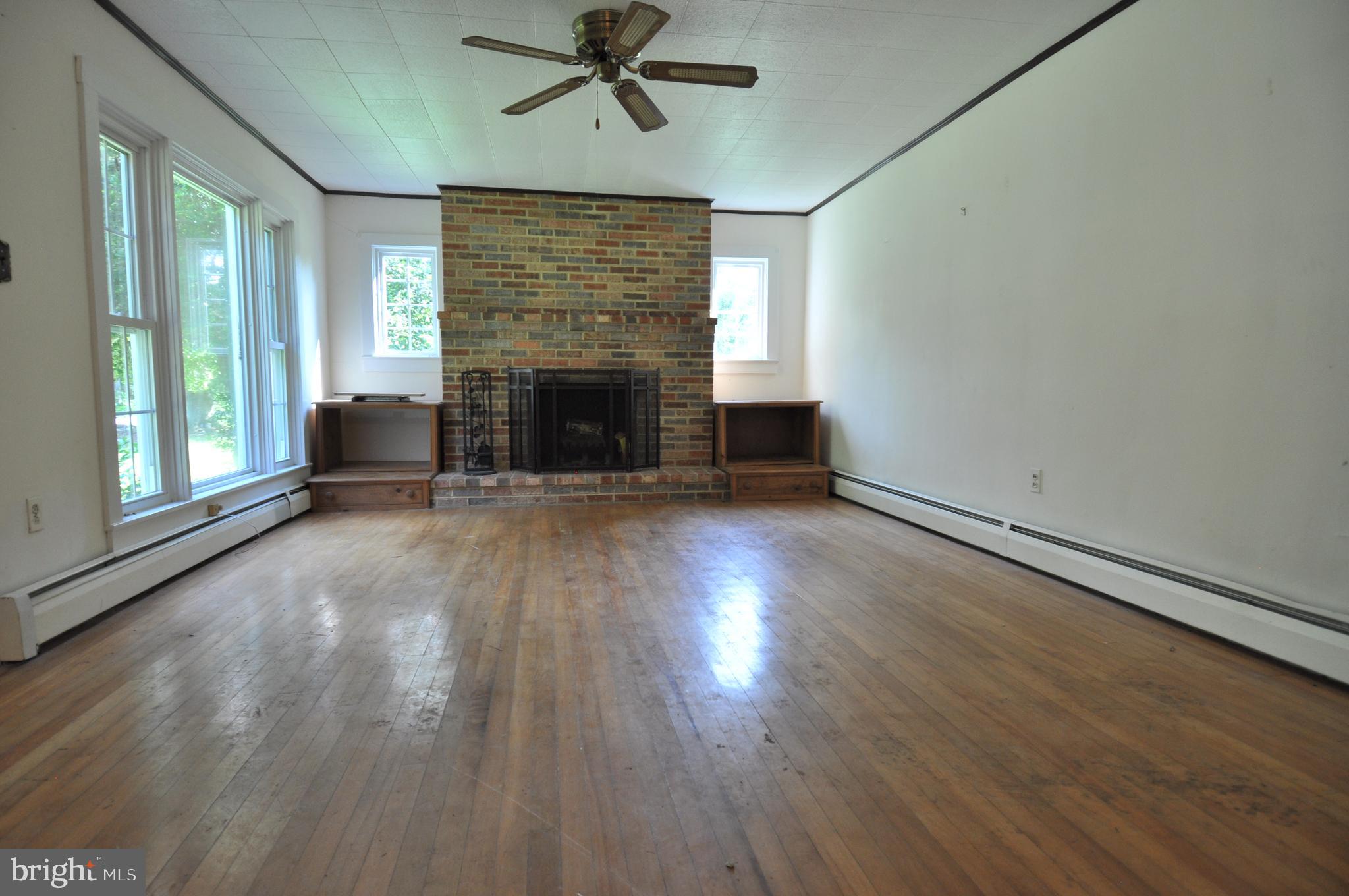 635 Cedar Hall Road Pocomoke City, MD 21851 - Photo 6 of 48 an empty room with windows fireplace and wooden floor
