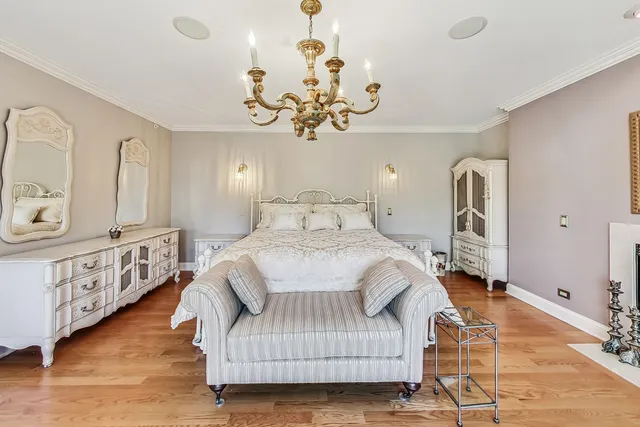 a bedroom with a large bed and a chandelier