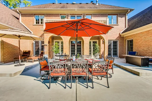a view of a patio with a table and chairs under an umbrella