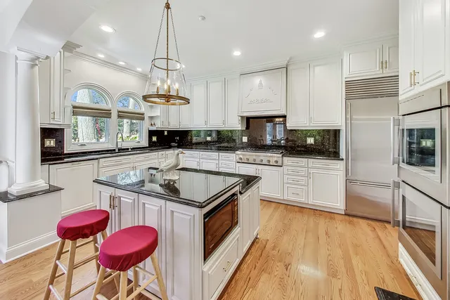 a kitchen with granite countertop a sink a counter top space appliances and cabinets