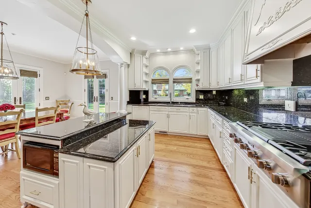 a kitchen with kitchen island granite countertop a sink cabinets and stainless steel appliances