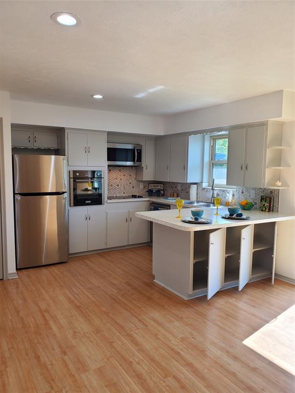 a kitchen with wooden floors and stainless steel appliances