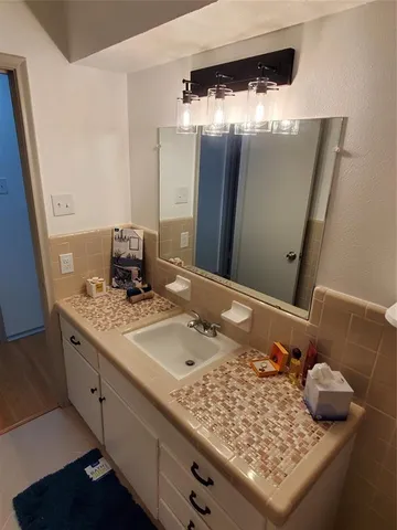 a bathroom with a granite countertop sink and a mirror