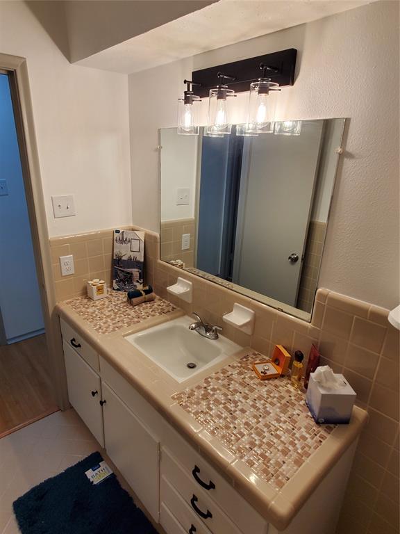 7424 Walling Lane Dallas, TX 75231 - Photo 15 of 19 a bathroom with a granite countertop sink and a mirror