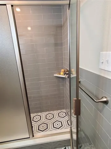 a bathroom with a shower and mirror