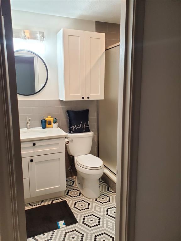 7424 Walling Lane Dallas, TX 75231 - Photo 10 of 19 a bathroom with a toilet a sink and a mirror